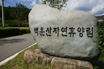 백운산자연휴양림의 표지석(좌)과 휴양림 내 물레방아의 모습(우).